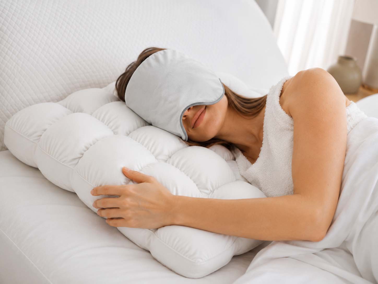 Woman sleeping with cooling pillow and weighted eye mask